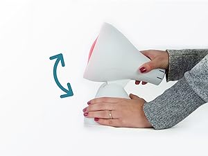 Dispositivo cónico blanco manipulado con las manos. La flecha azul indica una característica giratoria o ajustable. Parece ser un artículo doméstico o de cuidado personal.