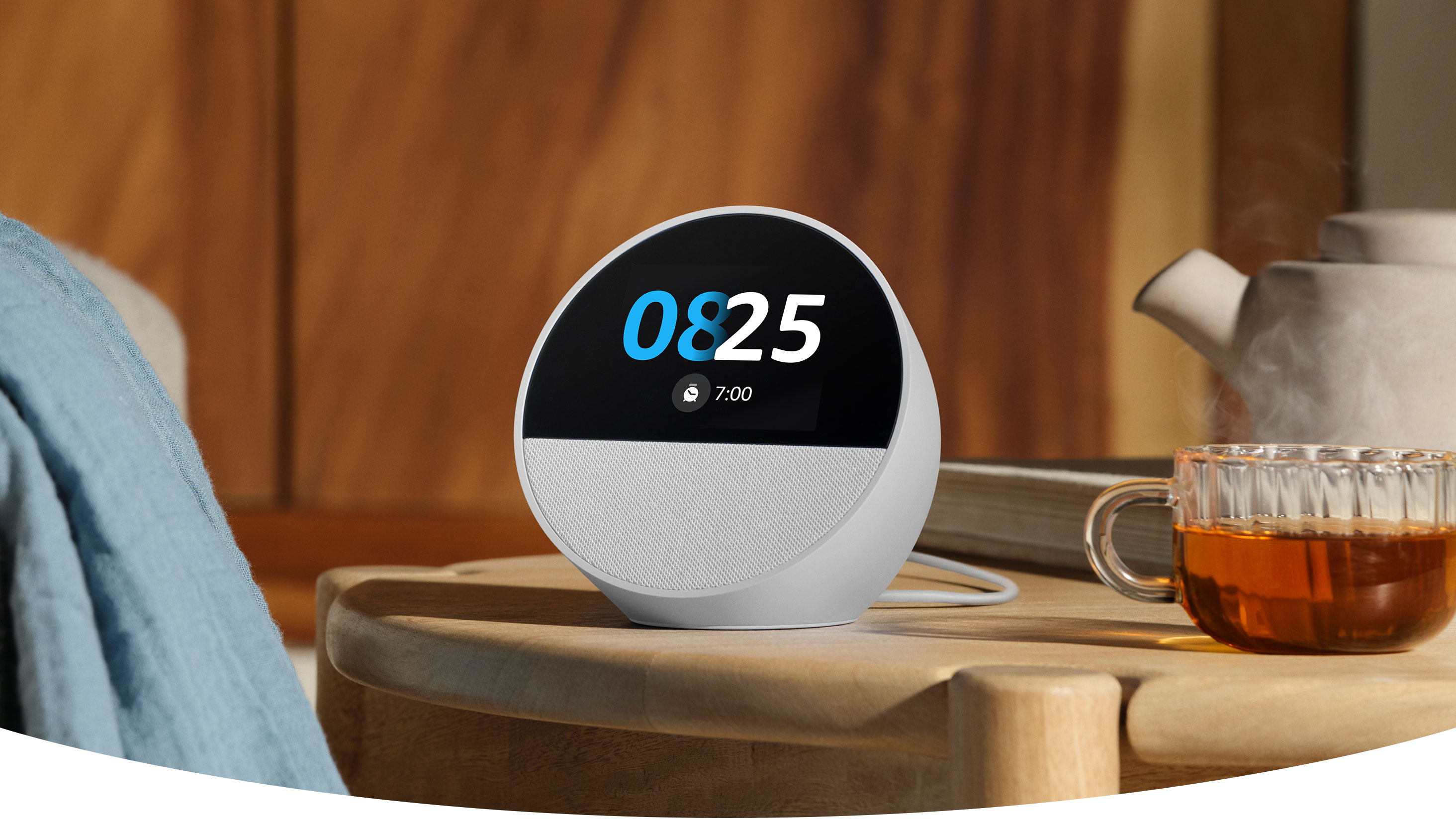 Echo Spot blanco sobre una mesita de noche mostrando la hora en pantalla